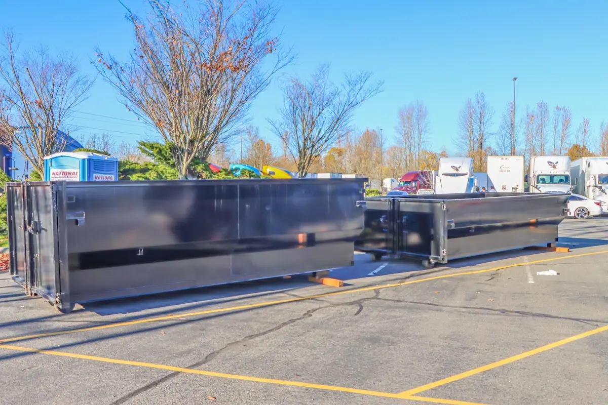 Professional dumpster rental service with roll-off container on residential driveway in Cold Spring